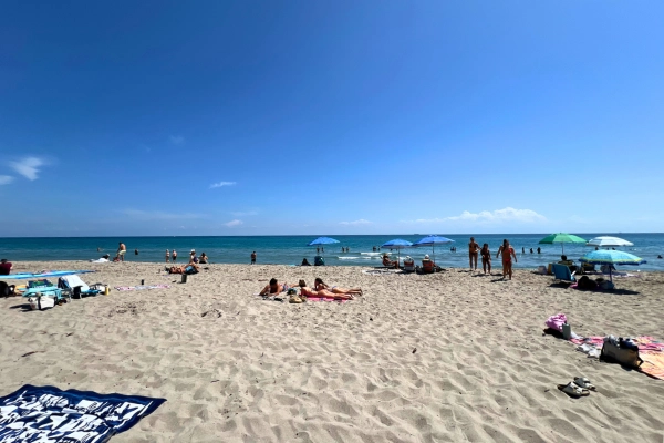 Blue sky and sand with people and umbrellas in Delray Beach Florida