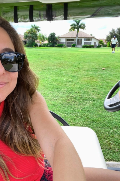 View of woman taking photo in a golf cart in residential Florida neighborhood