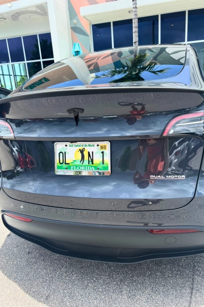Back of a Tesla with a license plate reading OL N 1 a joke local Floridians love