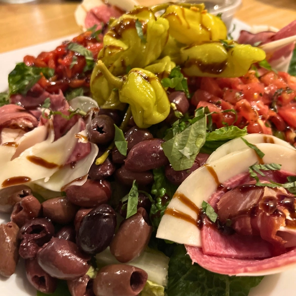 Antipasto salad full of meats tomatoes cheese and olives appetizer at Pizza Time Caffe in Parkland Florida Italian cuisine