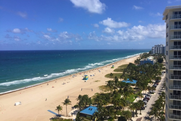 View from high rise building in Pompano Beach Florida of beach ocean and palm trees