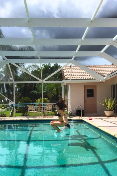 Girls jumping into pool living in Florida